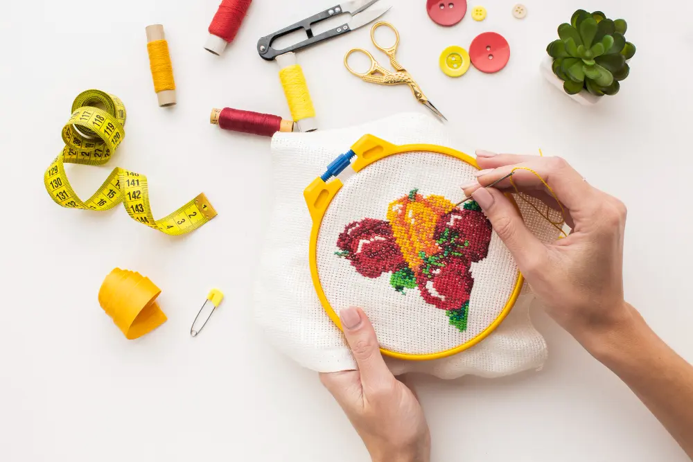 A girl doing some embroidery work with the help of needle and thread.