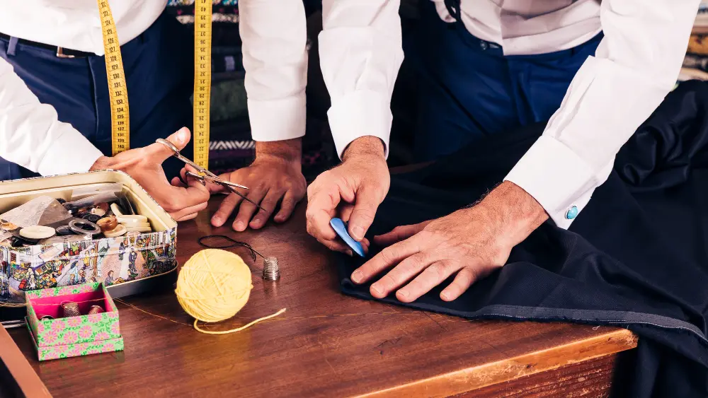 Two peoples working with chalk and scissor and doing alteration and repair